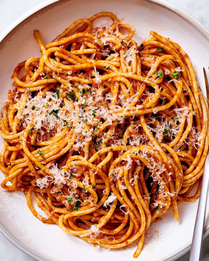Caramelized tomato paste pasta on plate.