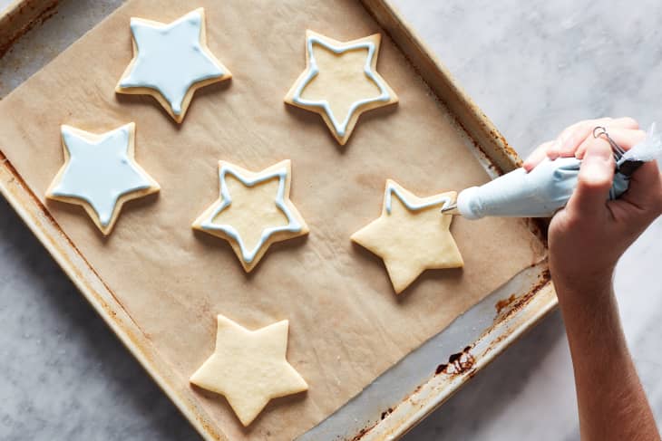 Royal icing being piped on cookie.