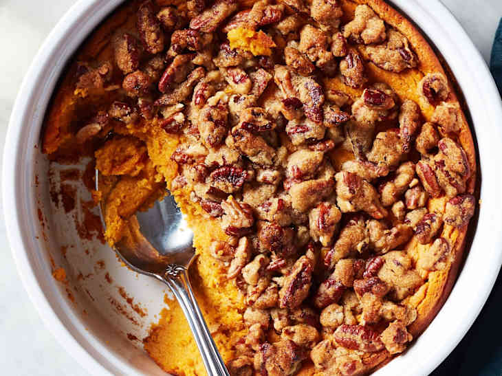 Serving spoon inside sweet potato souffle dish.