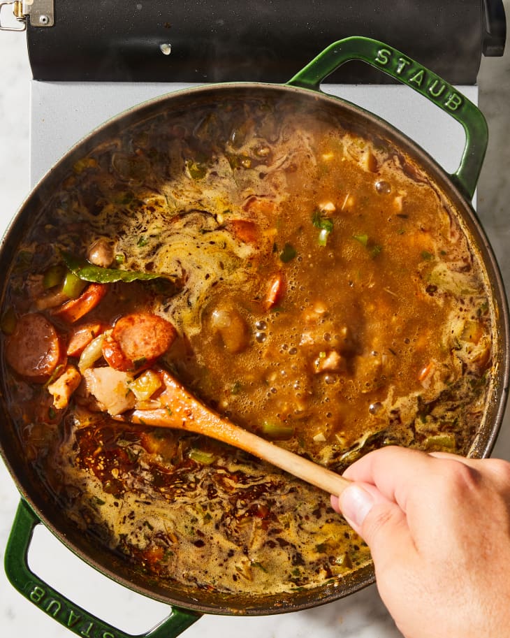 cajun gumbo being stirred in a pot