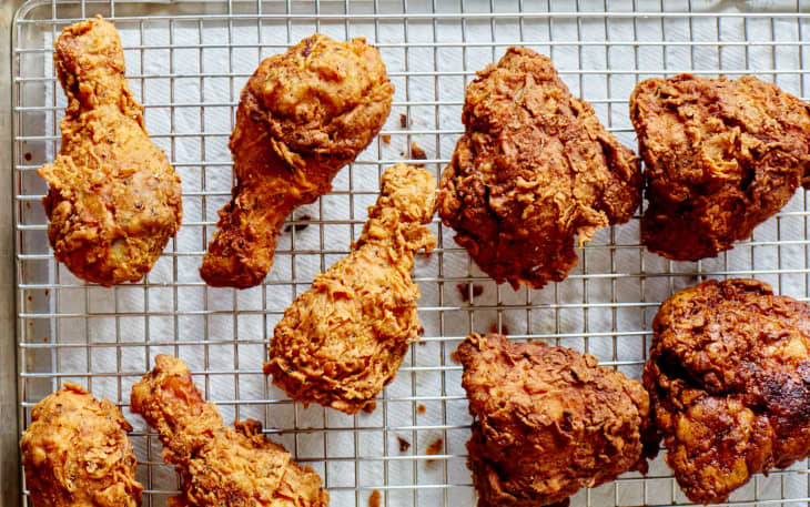 Crispy fried chicken pieces on a cooling rack, showcasing golden-brown texture.