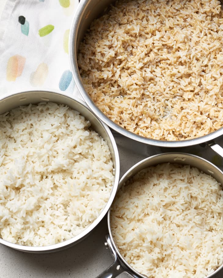 Overhead shot of three pots of different kinds of rice: long-grain white, brown, and jasmine