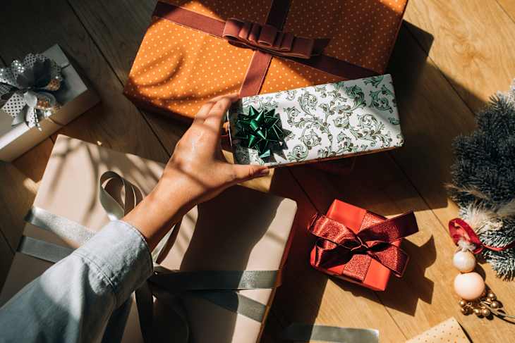 Hand of a Woman Holding a Wrapped Christmas Present