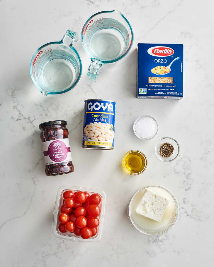 Ingredients for Greek orzo: cherry tomatoes, feta, white beans, kalamata olives, orzo, olive oil, salt, and pepper.