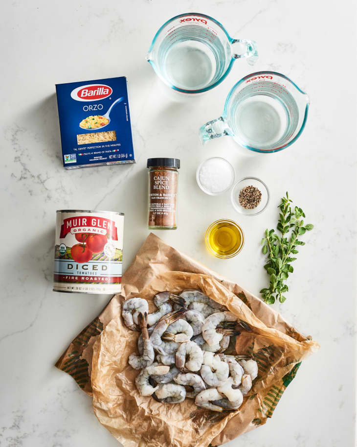 Ingredients for Smoky Cajun Shrimp Orzo: raw shrimp, orzo, diced tomatoes, Cajun spice, olive oil, herbs, and water.