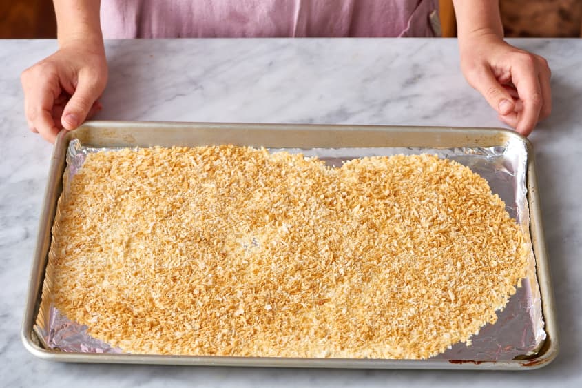 Breadcrumbs spread on a foil-lined baking sheet, ready for crispy chicken preparation.