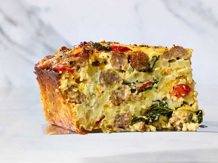 head on shot of a slice of breakfast casserole on a marble surface