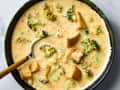 overhead shot of broccoli cheddar soup in a bowl, with a spoon