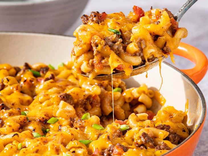 someone scooping out casserole from pot