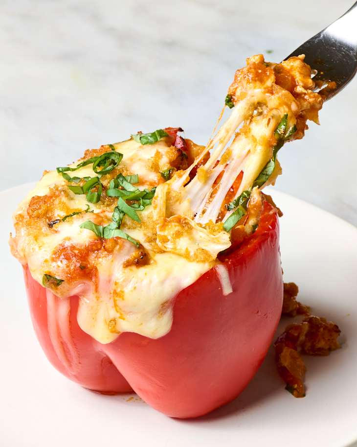 angled shot of a fork pulling out a serving from the stuffed pepper on a small white plate
