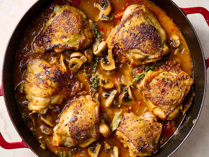 chicken chassuer in a red pot with a dark interior