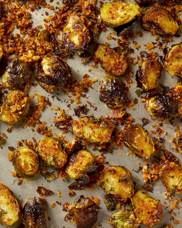 Overhead shot of baked chili crisp brussels sprouts on a baking sheet.
