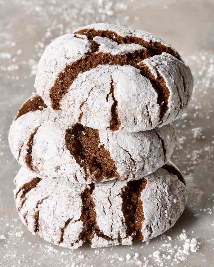 angled shot of three chocolate crinkle cookies stacked on to each other