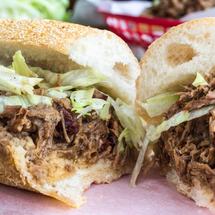 Shredded roast beef po' boy sandwich with lettuce on a crusty roll.