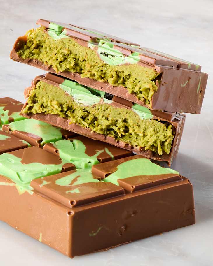 Layered chocolate bars with a green filling, showcasing a marbled design on top.