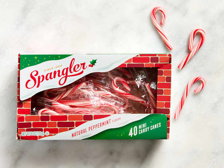 Box of Spangler mini candy canes with a brick-pattern design, featuring several candy canes scattered around.
