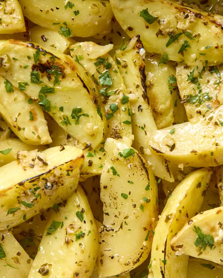 close up shot of greek lemon potatoes, topped with herbs