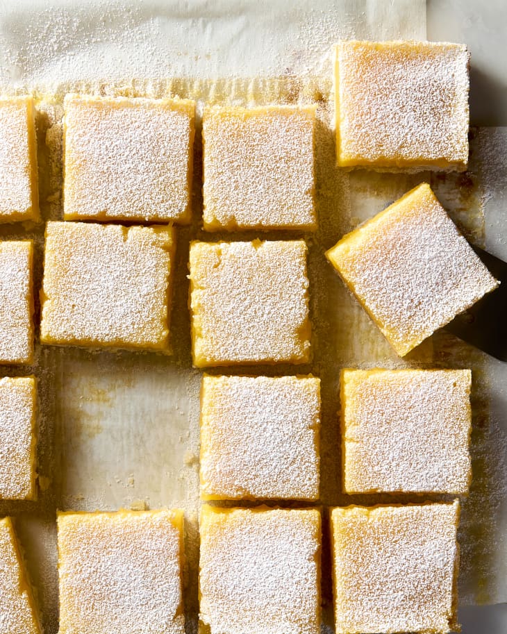 overhead shot of lemon bar slices on a piece of parchment paper.