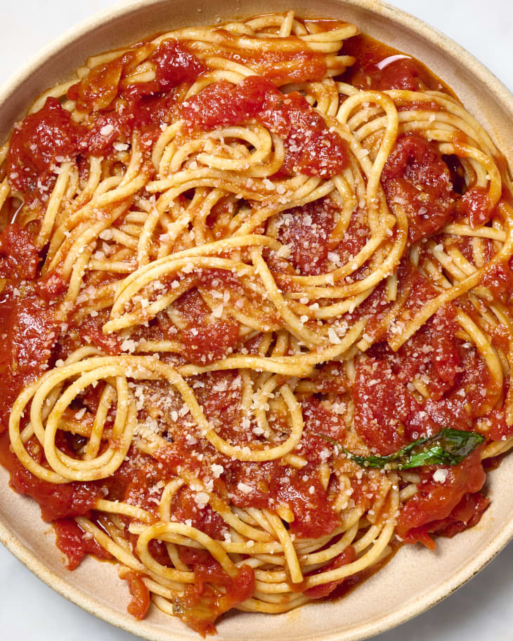 overhead shot of spaghetti marinara on a plate, topped with parmesan