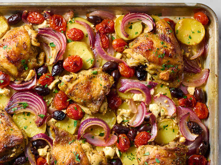 overhead shot of sheet pan greek chicken with olives, onions, tomatoes and potatoes