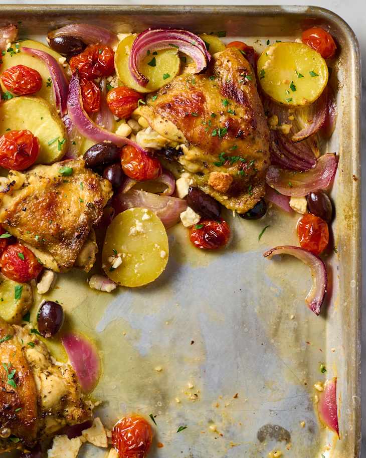 overhead shot of sheet pan greek chicken with olives, onions, tomatoes and potatoes