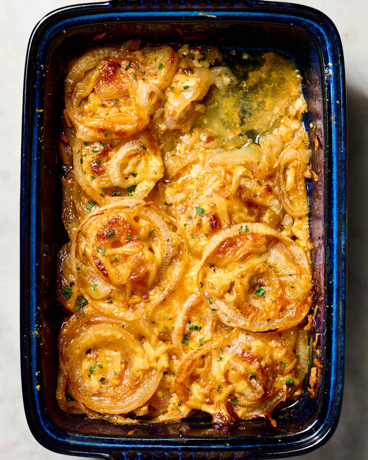 Baked dish featuring golden, caramelized onions and melted cheese, garnished with fresh parsley.