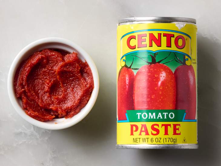 A can of Cento tomato paste next to a small bowl of tomato paste