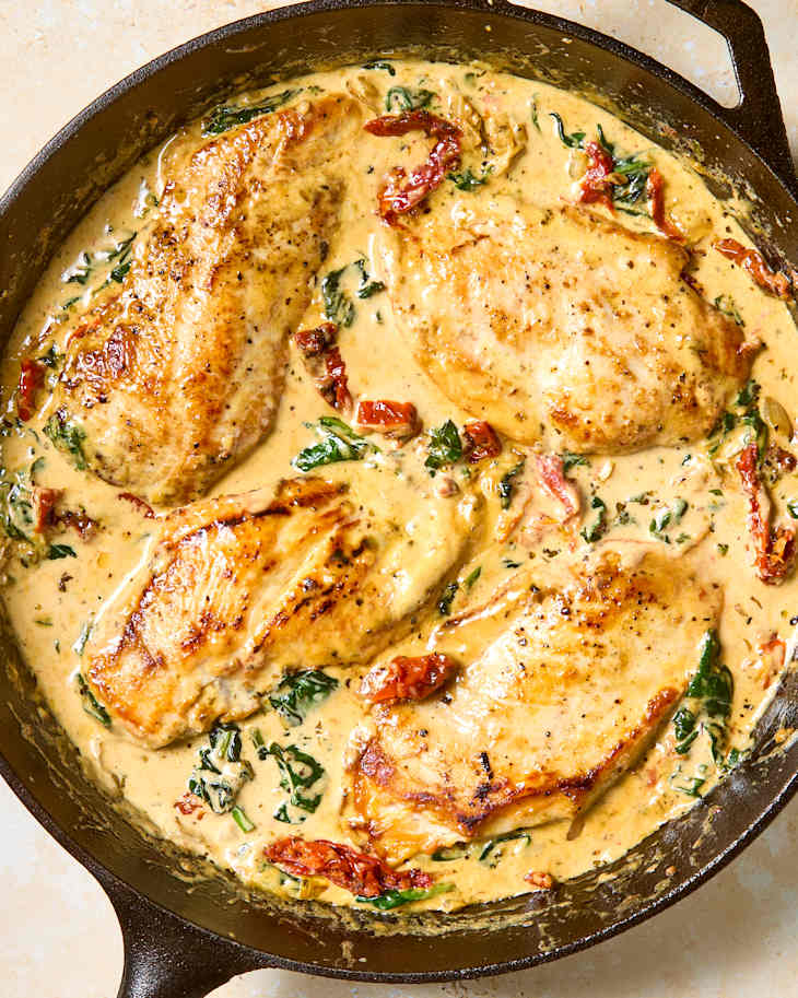 overhead shot of tuscan chicken in a cast iron skillet.
