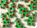 Photograph of Christmas tree cookies on a white plate.