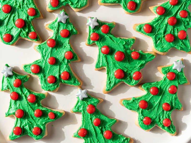 Photograph of Christmas tree cookies on a white plate.